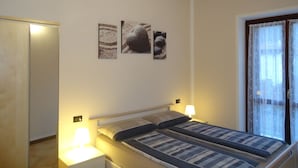 Une chambre à coucher avec un lit, des lampes de chevet et une fenêtre avec des rideaux.