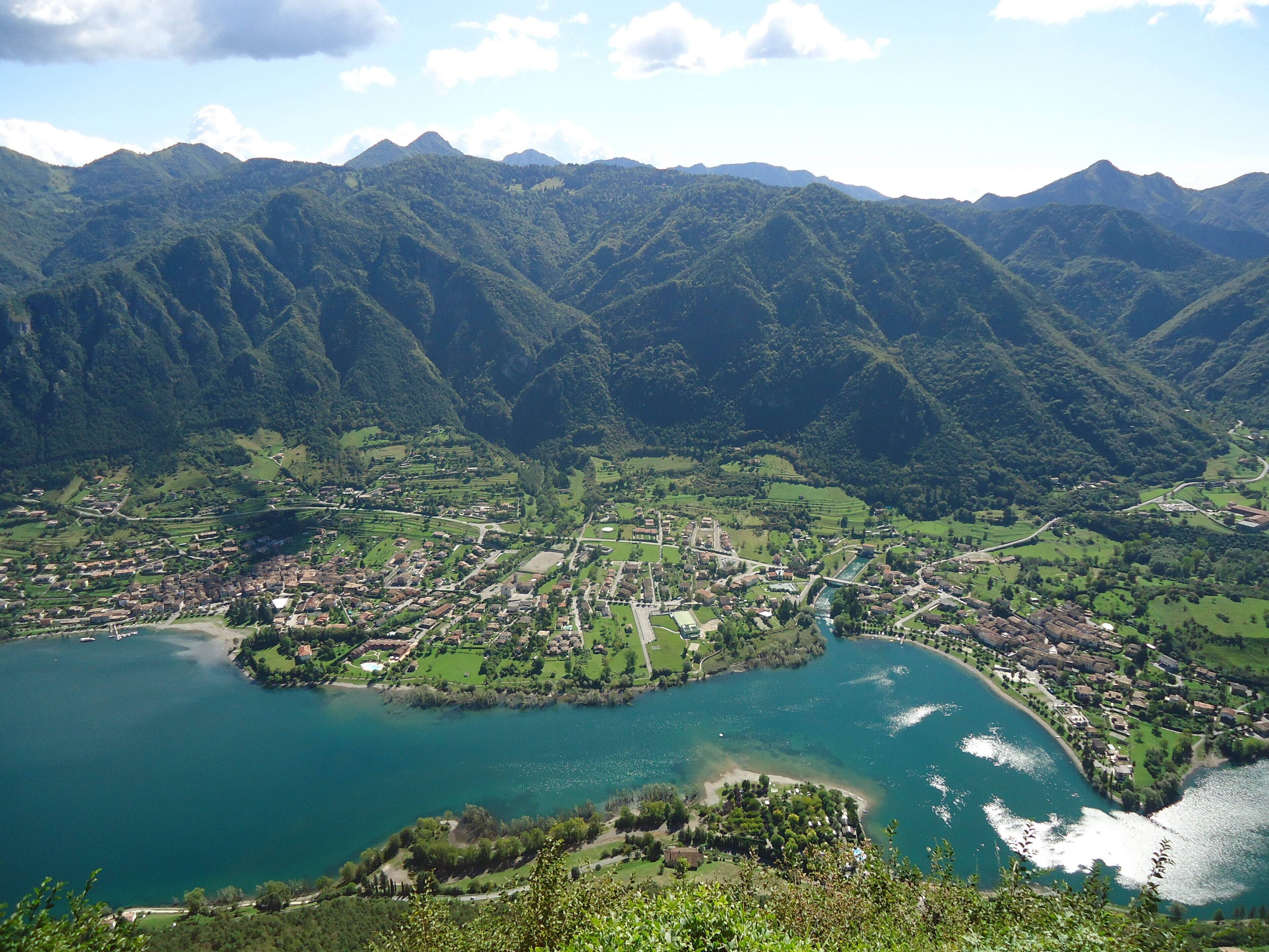 Paesaggio montuoso con una città e un lago.