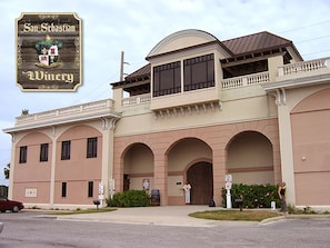 Um edifício com uma grande entrada em arco, uma varanda e uma placa com o texto