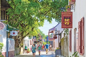 A street lined with buildings, some with signs, and pedestrians walking. - New! Victorian Apartment. Park & Walk Everywhere in Town (St. Augustine)