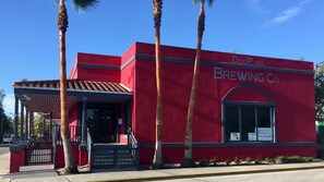 A red building with a sign reading "DogRose Brewing Co." and a covered entrance. - New! Victorian Apartment. Park & Walk Everywhere in Town (St. Augustine)