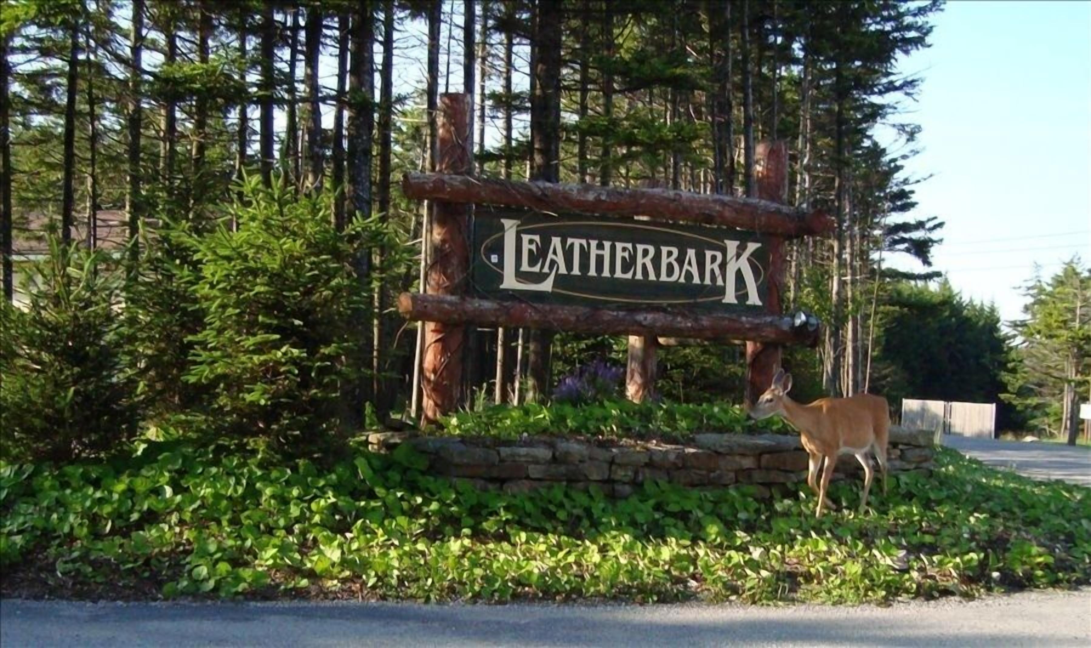 A sign with the name 'Leatherbark' surrounded by greenery and a deer.