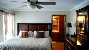 A neatly made bed with a headboard, a dresser with a mirror, and a ceiling fan. - Best Deal in Almost Heaven!! (Snowshoe)