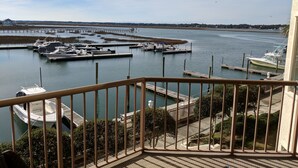 A marina with boats docked, a pier extending into the water, and a view of the surrounding landscape. - MARLIN QUAY,  2 BR , 2  bath , Unit 205, ELEVATOR,  Pools, overlooks Marina<br> (Murrells Inlet)
