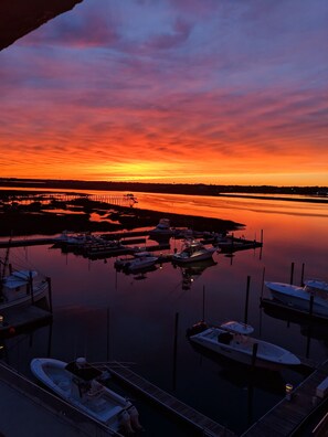 A marina at sunset with boats docked and a pier extending into the water. - MARLIN QUAY, 2 BR , 2 bath , Unit 205, ELEVATOR, Pools, overlooks Marina<br> (Murrells Inlet)