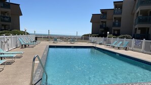 A swimming pool with lounge chairs and a white fence. - APATBIII Ocean Side/Ocean View 9520 SHORE DR 3P Family friendly.  (Myrtle Beach)