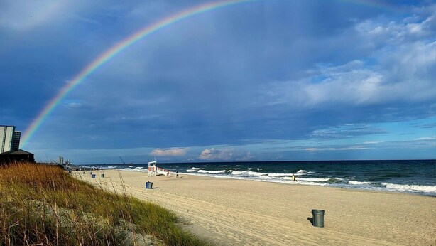 A beach with a visible rainbow, sandy shore, and ocean waves. - APATBIII Ocean Side/Ocean View 9520 SHORE DR 3P Family friendly.  (Myrtle Beach)