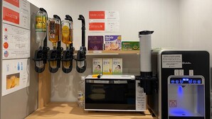 A coffee machine with multiple dispensers, a tea machine, and a water dispenser. - JAKOTEL Plus Namba (Osaka)