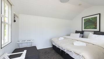 Un dormitorio con una cama grande, una ventana, un techo blanco y un cuadro en la pared.