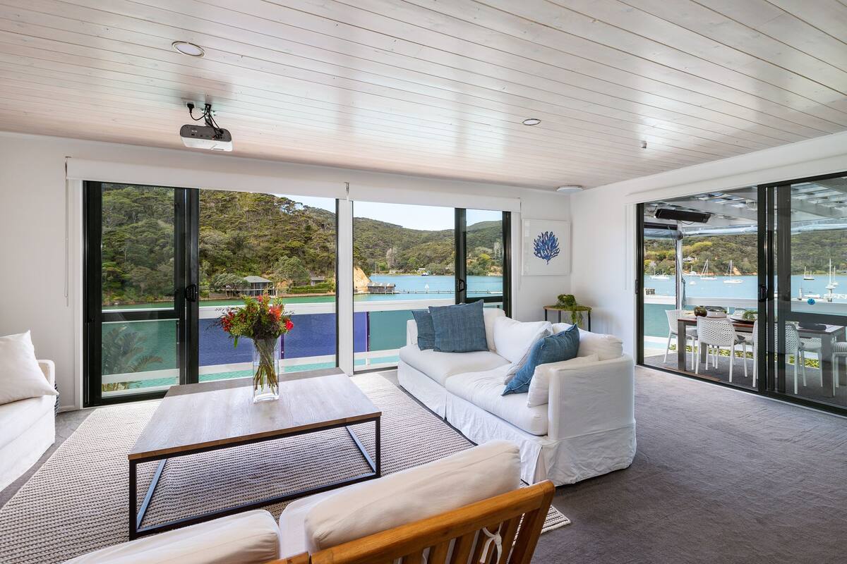 A spacious balcony with a view of a lake and hills.