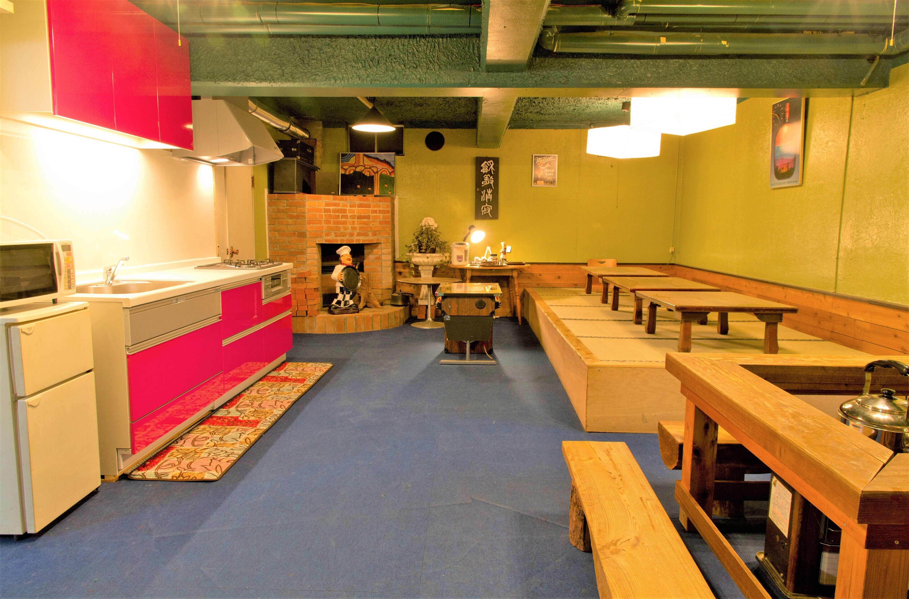Een restaurant met een keukenhoek, houten tafels en banken.