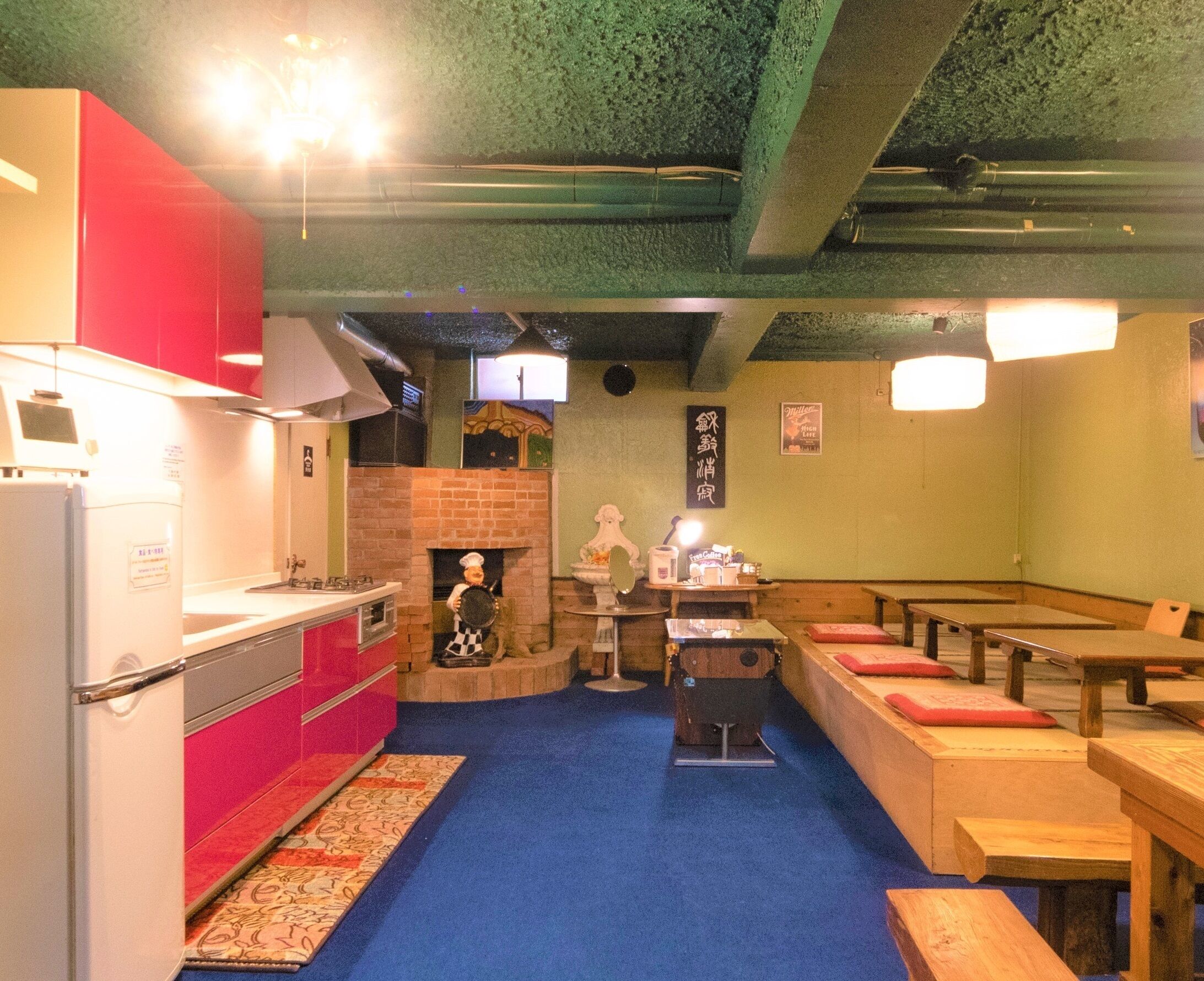 A restaurant with a kitchen area, wooden tables, and benches.