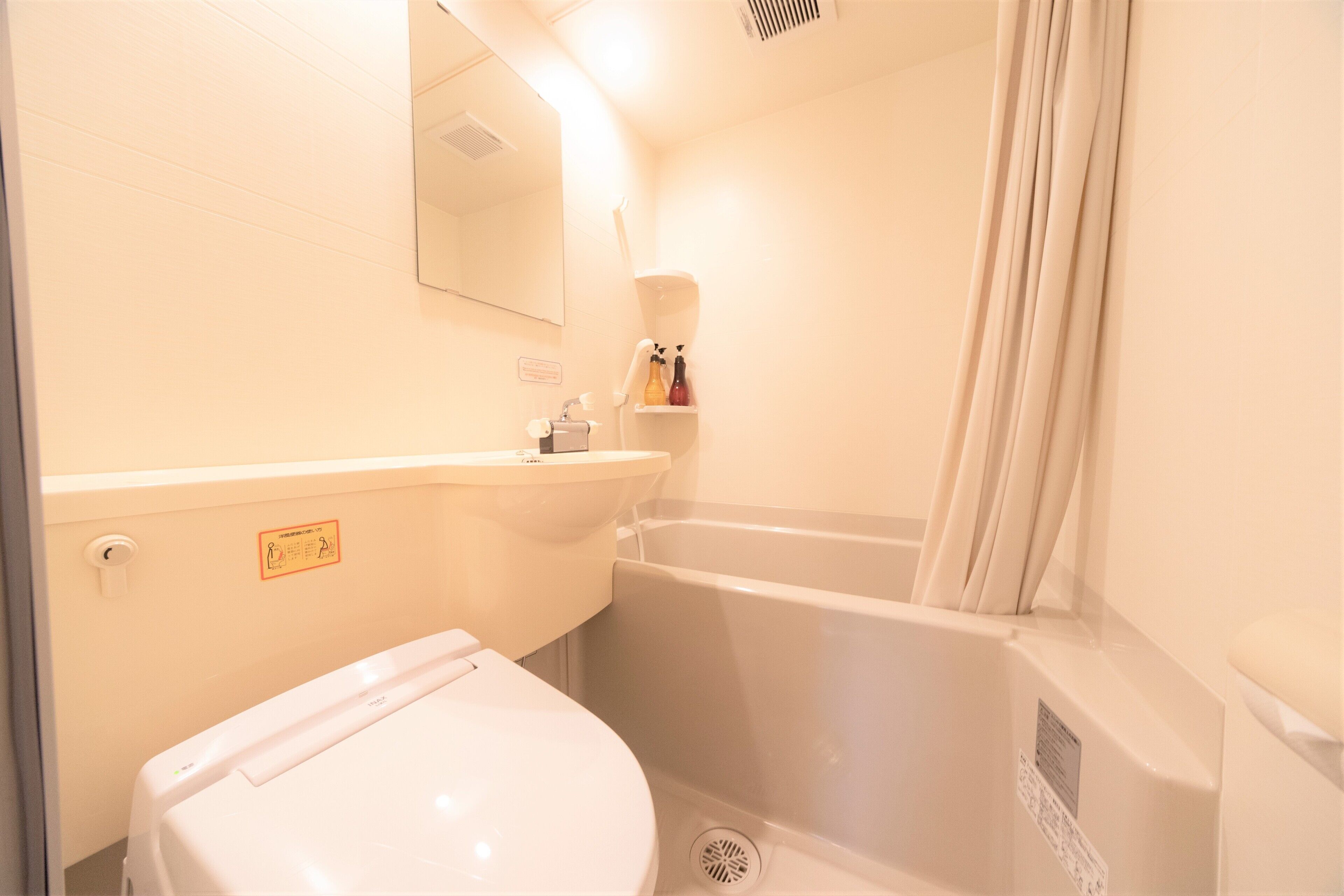 A bathroom with a toilet, sink, and bathtub.