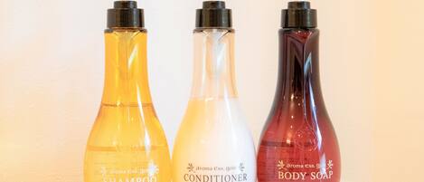 Tres botellas de champú, acondicionador y jabón de cuerpo.