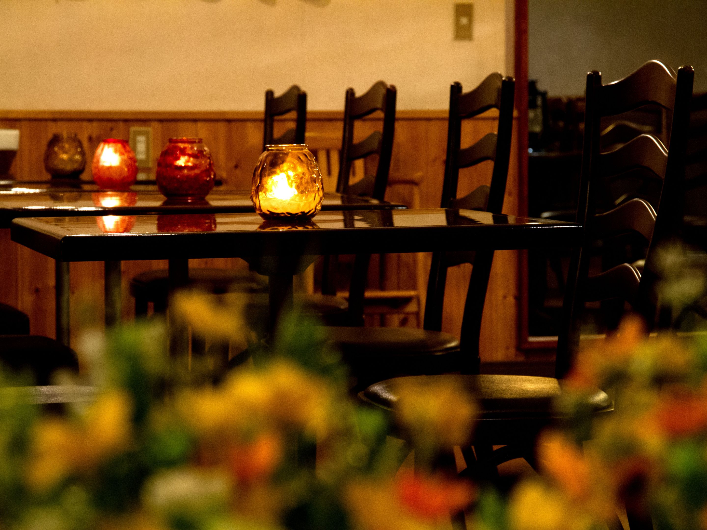 A dining table with chairs, candles, and a vase.