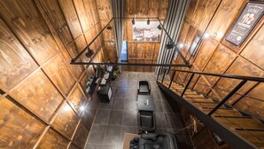 Een kamer met hoge plafonds, houten lambrisering, een bureau, twee stoelen en een uitzicht door een raam.