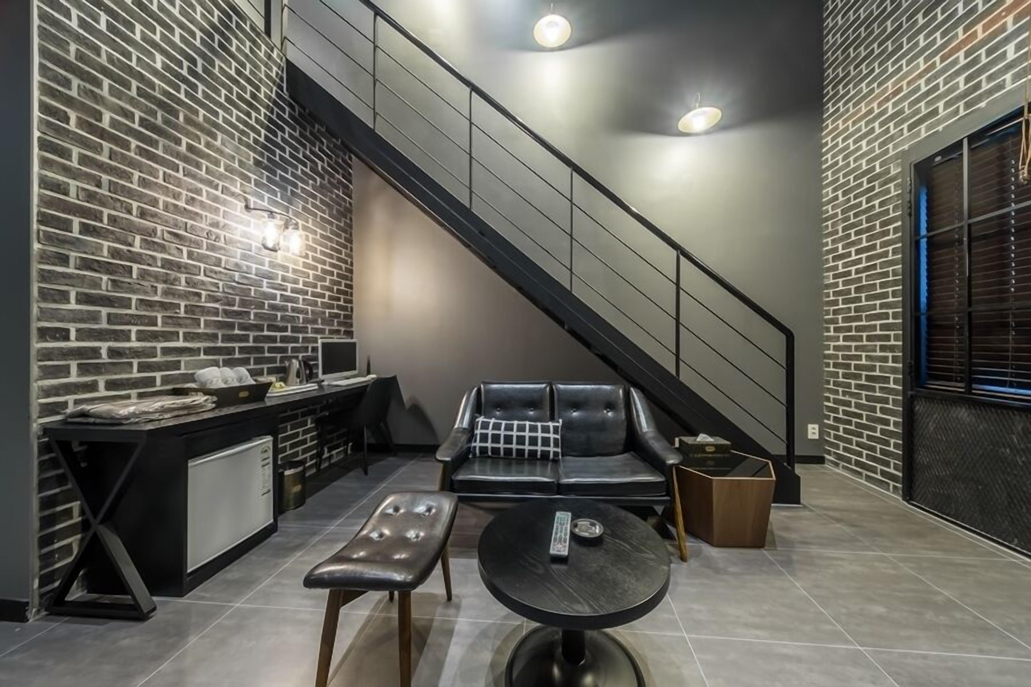 A modern kitchen with a black countertop, a built-in oven, and a black bench.
