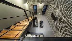 Een modern interieur met een bakstenen muur, een trap en een zithoek met een tafel en stoelen.