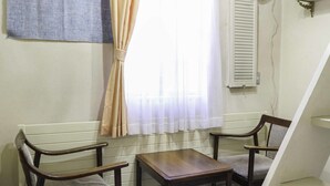 A room with two wooden chairs, a small table, a window with curtains, and a radiator. - Pension Ohayo (Hakuba)