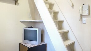 A staircase with a white handrail and a wall-mounted intercom. - Pension Ohayo (Hakuba)