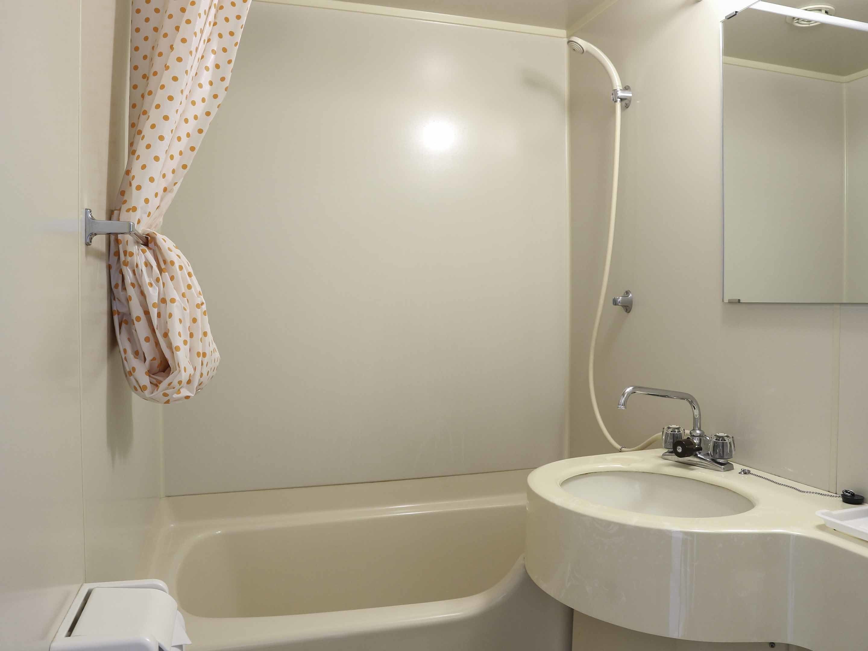 Kombinasi shower/bathtub, perlengkapan mandi gratis, sandal, dan handuk
