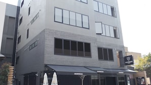 Ein mehrstöckiges Gebäude mit modernem architektonischen Design, das große Fenster und eine Ziegel-Fassade aufweist.