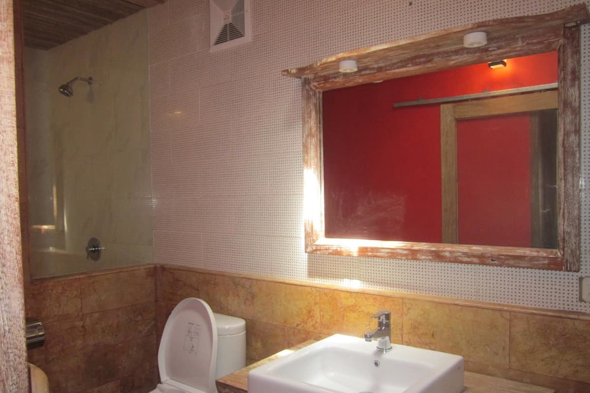 Une salle de bain avec des toilettes, un lavabo et une douche.