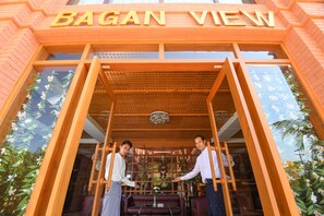 A building entrance with the sign "BAGAN VIEW" and a wooden structure with a lattice roof. - Bagan View Hotel (Nyaung-U)