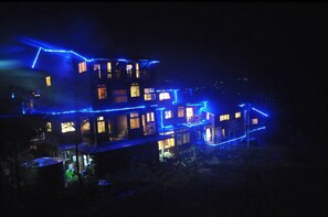 A multi-story building with illuminated blue lines outlining its structure.