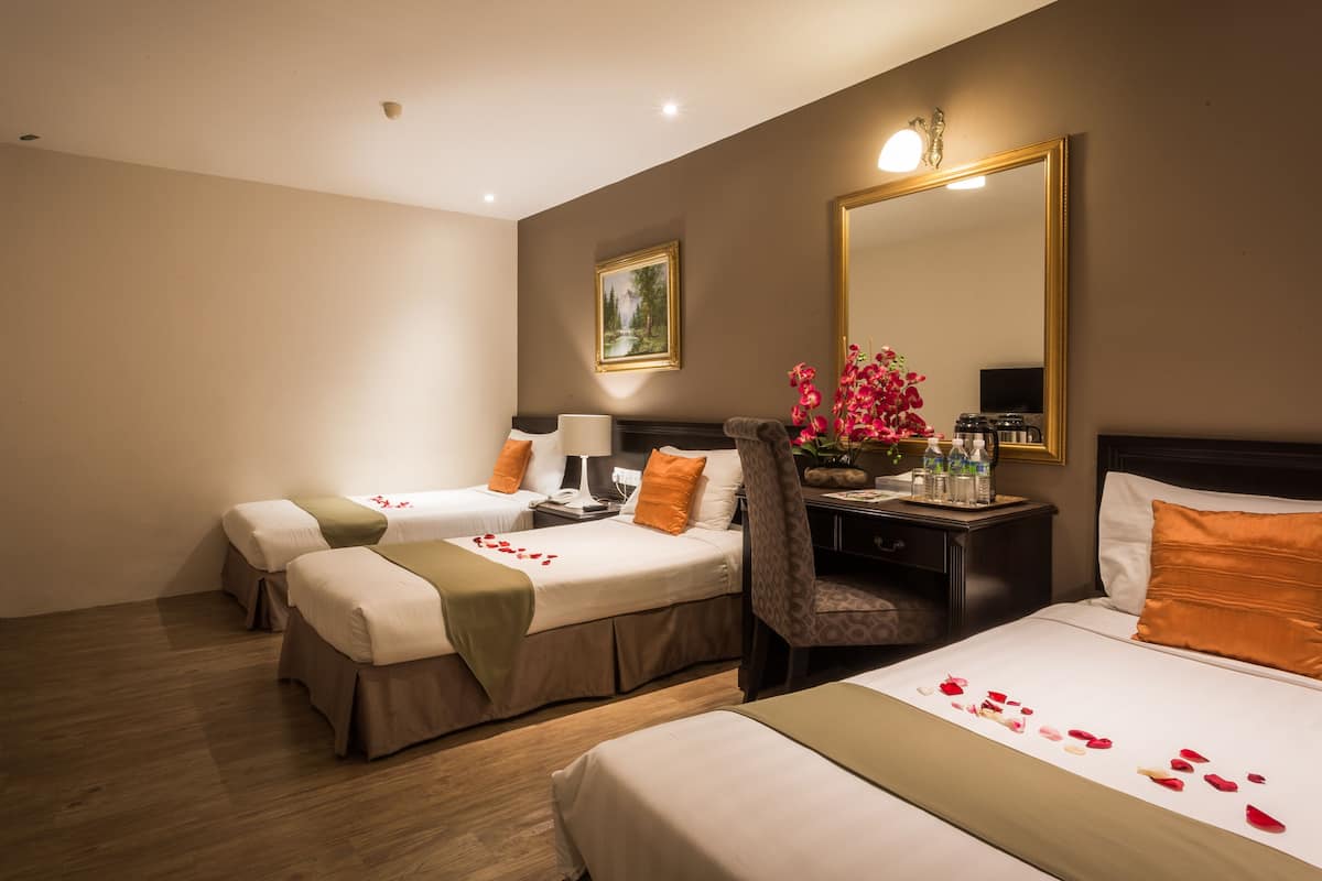 Une chambre d’hôtel avec deux lits, un bureau, une chaise, un miroir et un téléviseur.