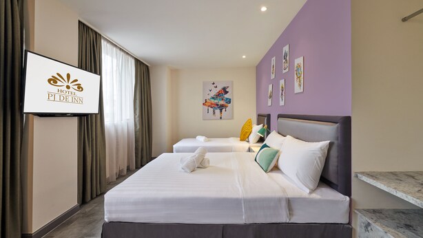 Habitación de hotel con dos camas, televisión, obras de arte en la pared y un banco de mármol.