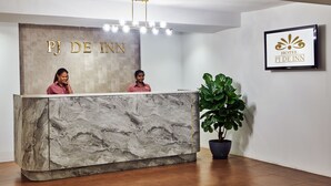 Un mostrador de recepción de hotel con encimera de mármol y un cartel que dice "PJ DE INN".