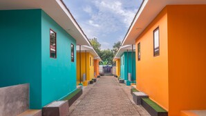 Un pasillo con paredes de colores y piso de baldosas, que lleva a una reja.