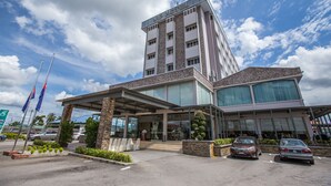 A modern hotel with a prominent "VIP HOTEL" sign, a covered entrance, and a parking area with cars. - VIP Hotel Segamat (Segamat)