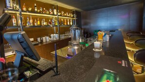 A bar area with a long counter, shelves with bottles, a blender, and a laptop. - VIP Hotel Segamat (Segamat)