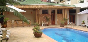 Una piscina al aire libre, sombrillas, tumbonas