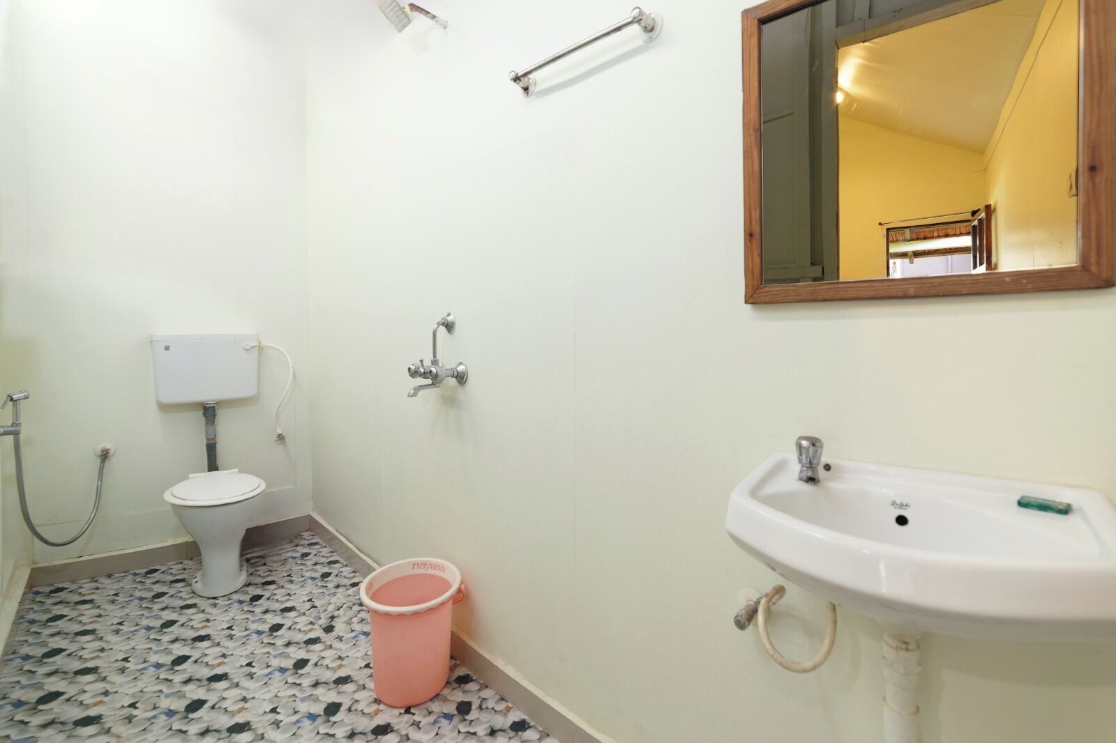 Un baño con inodoro, bidé, lavamanos y un espejo.