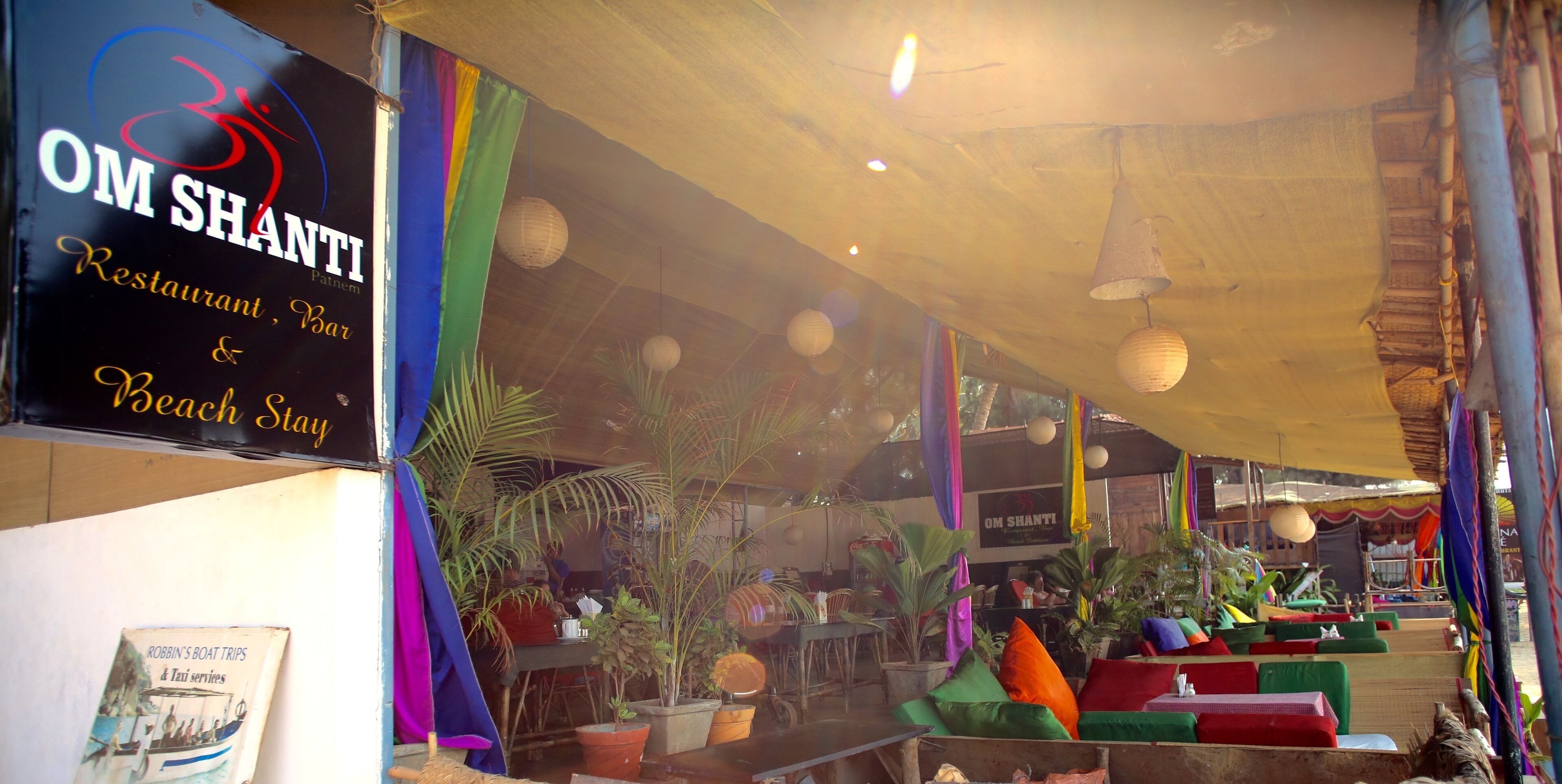 Un restaurante con cortinas de colores y farolillos de papel colgando.