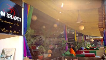 Un restaurante con cortinas de colores y farolillos de papel colgando.