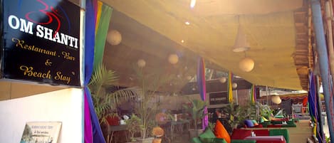 Un restaurante con cortinas de colores y farolillos de papel colgando.