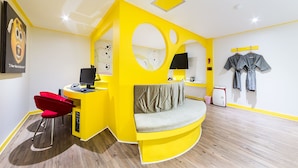 A brightly colored room with a yellow desk, red chair, and a curved seating area. - In Hotel (Suwon)