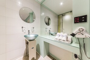 A bathroom with a glass sink, two mirrors, a hairdryer, and a towel rack. - In Hotel (Suwon)