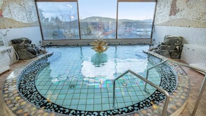 A circular indoor pool with a mosaic tile design, large windows, and a view of a distant landscape. - Ama no shima (Toba)