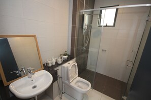 A modern bathroom with a sink, toilet, and glass-enclosed shower. - Damen A1713A (Subang Jaya)