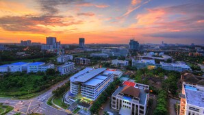 A cityscape at sunset with modern buildings, roads, and a mix of greenery. - Cybersquare B2210 (Cyberjaya)