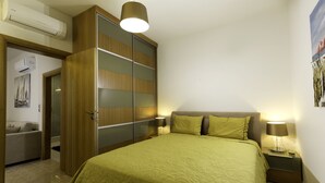 A bedroom with a bed, a wardrobe, a nightstand, and a lamp. - Antigone Estate (Rhodes)