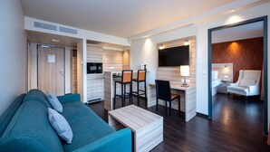 Een moderne woonkamer met een bank, een salontafel en een werkhoek met stoelen.