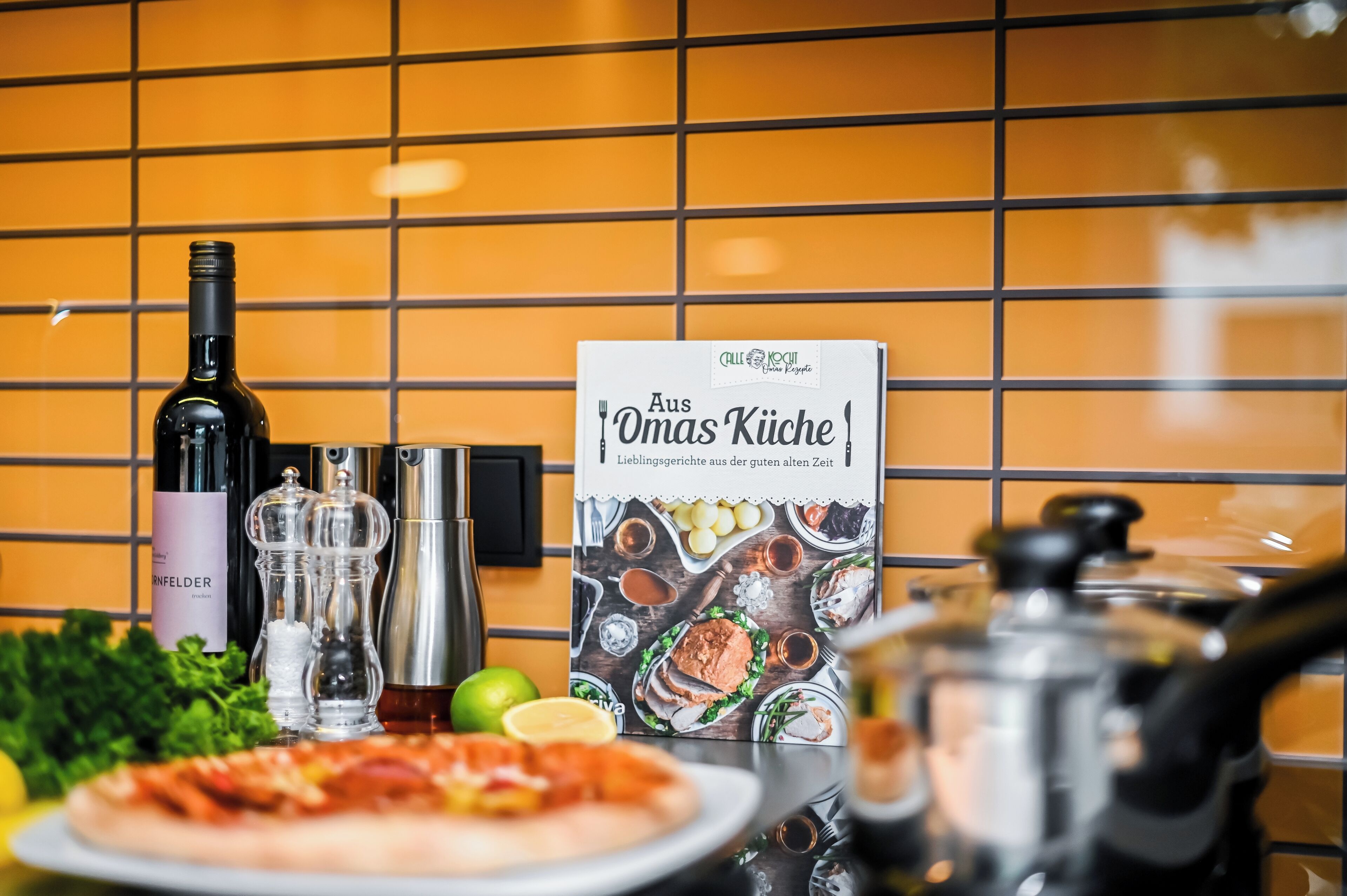Eine Küchenarbeitsplatte mit einer Weinflasche, Salz- und Pfefferdosen, einer Speisekarte und einer Pizza.