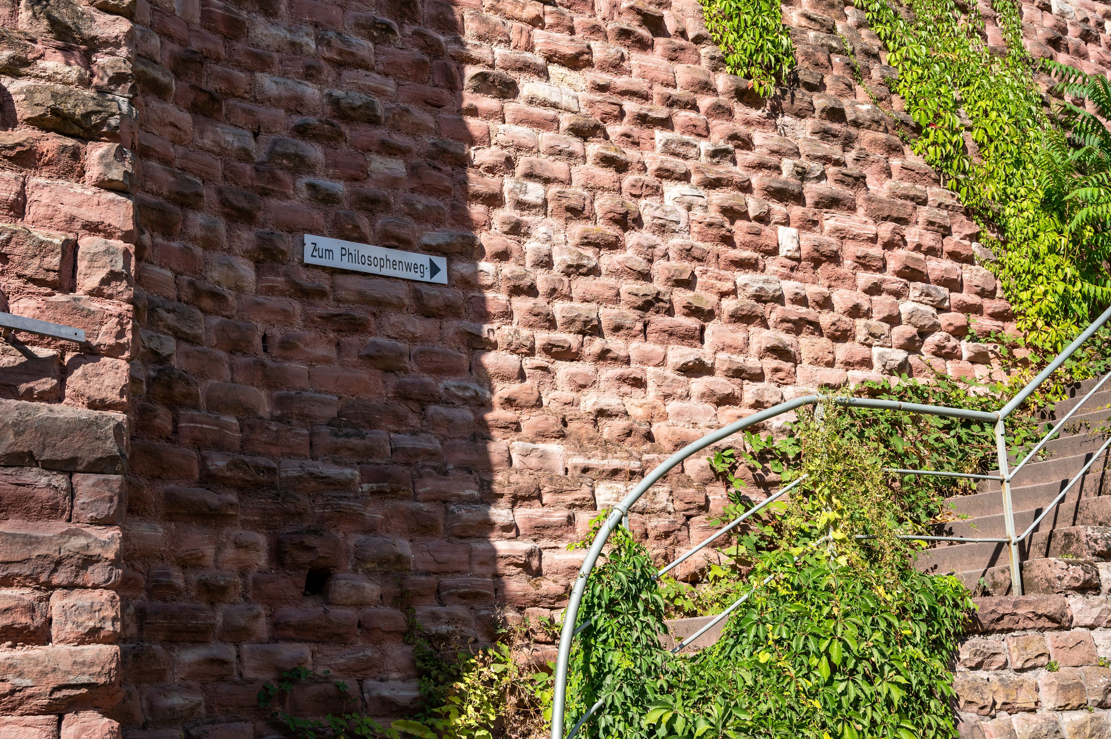 A brick wall with a sign reading "Zum Philosophenweg."
