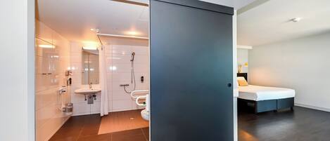 A modern bathroom with a shower, toilet, and sink.